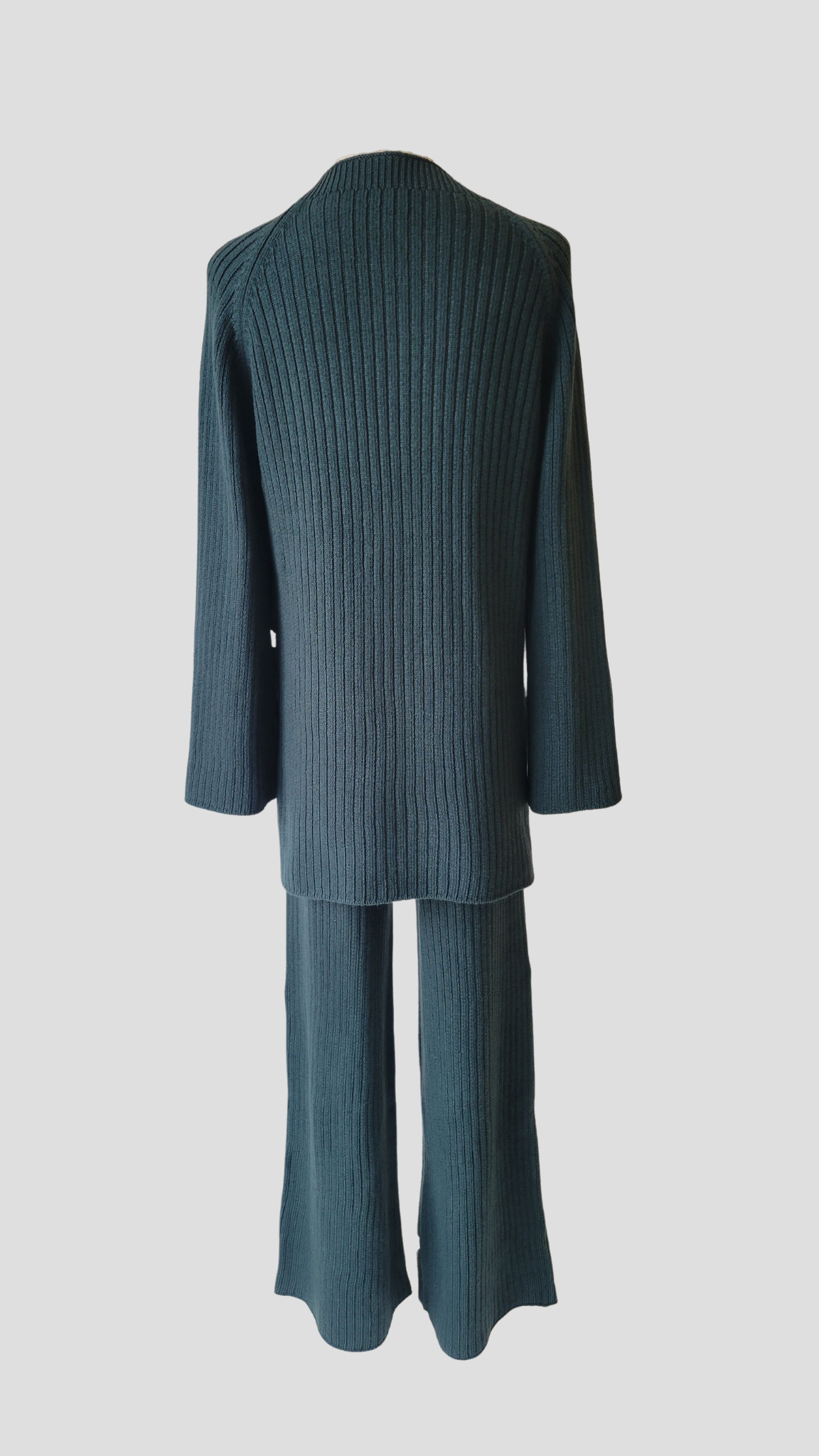 A chic two-piece knit co-ord set in 'Spruce', a dark teal colour. The set includes a comfy sweater with a relaxed fit and matching knit pants. Perfect for a stylish and cozy look.