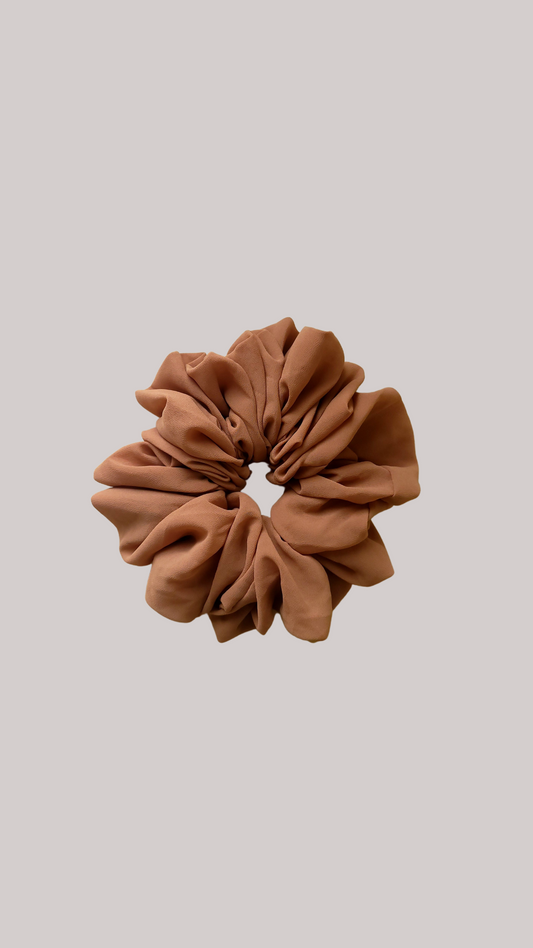 A chiffon scrunchie designed for wearing discreetly under a hijab or undercap. The scrunchie is made from soft and lightweight chiffon fabric, ensuring comfort and minimizing friction against the skin.